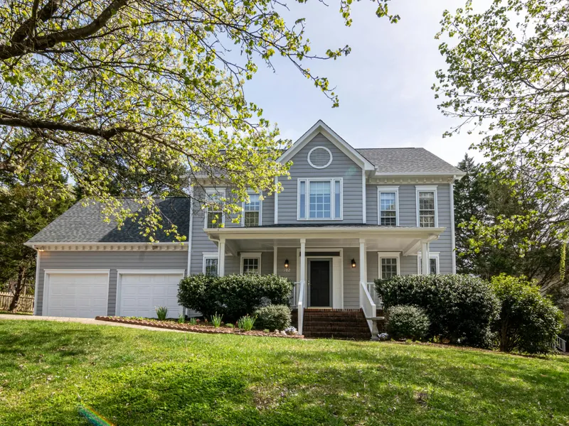 Two-story colonial home with blue-gray siding and new gray asphalt shingle roof, featuring a covered front porch